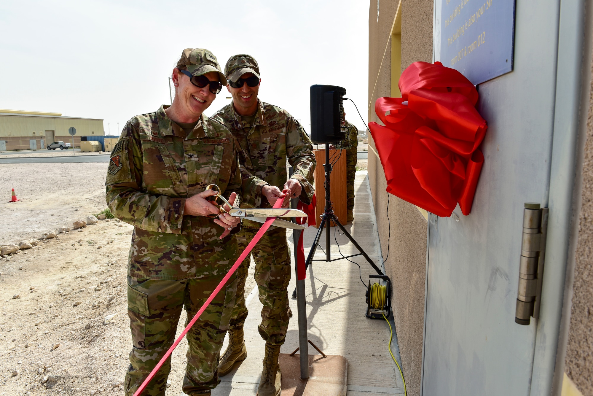 Col. Tara White, 379th Expeditionary Mission Support Group commander, and Maj. Jason Gargan, 379th Expeditionary Communications Squadron commander, cut a ribbon to commemorate the relocation of the wing's communication security office at Al Udeid Air Base, Qatar on Feb. 2, 2020. The new location is designed to enhance security and access for more than 40 unit account holders and 1,400 customers who rely on encrypted communication to conduct their missions throughout the U.S. Central Command area of responsibility. (U.S. Air Force photo by Tech. Sgt. John Wilkes)