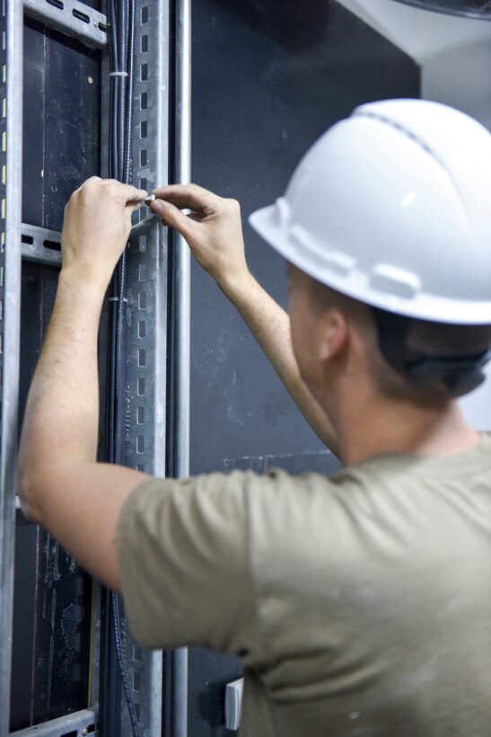 Staff Sgt. Rubin Chavez, 379th Expeditionary Communications Squadron cable and antenna systems supervisor, runs a cable for a mass announcement system at Al Udeid Air Base, Qatar on Feb. 19, 2020. The mass announcement system will be installed in buildings across the installation, enabling more effective communication during emergencies, increasing safety and readiness for personnel at AUAB. (U.S. Air Force photo by Tech. Sgt. John Wilkes)