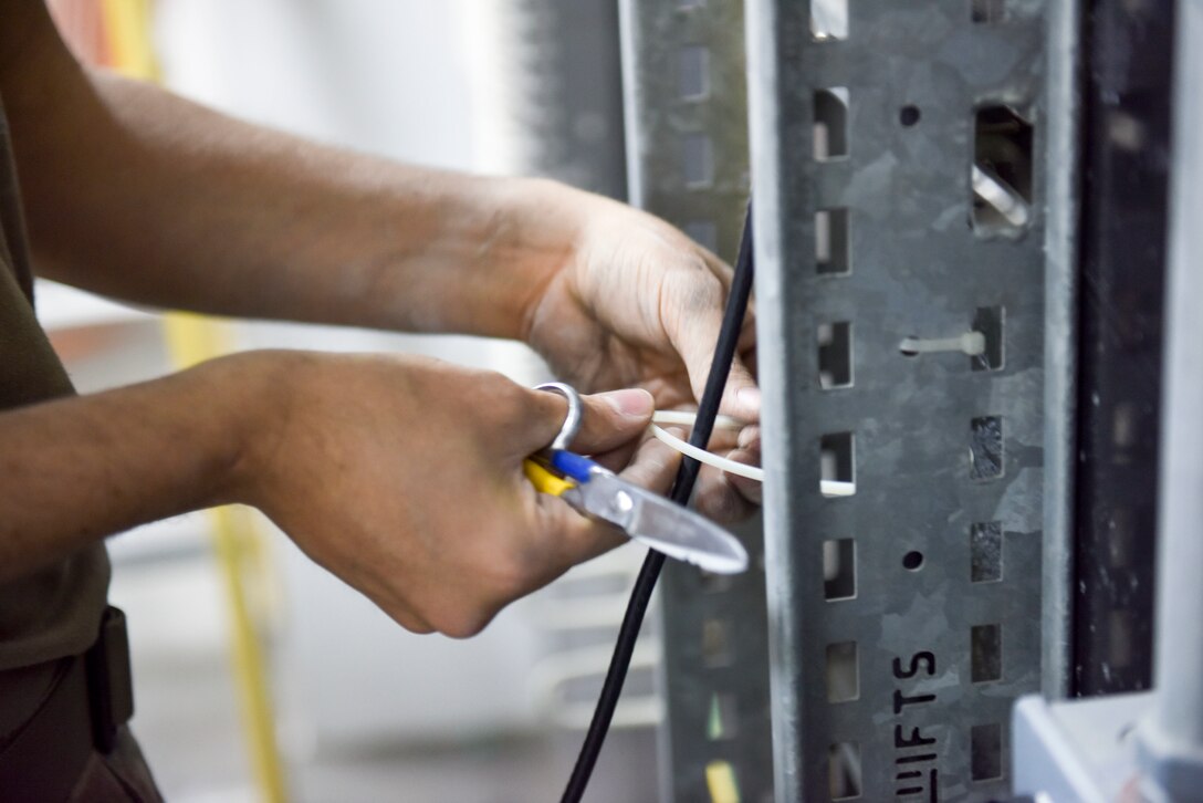 Staff Sgt. Rubin Chavez, 379th Expeditionary Communications Squadron cable and antenna systems supervisor, runs a cable for a mass announcement system at Al Udeid Air Base, Qatar on Feb. 19, 2020. The mass announcement system will be installed in buildings across the installation, enabling more effective communication during emergencies, increasing safety and readiness for personnel at AUAB. (U.S. Air Force photo by Tech. Sgt. John Wilkes)