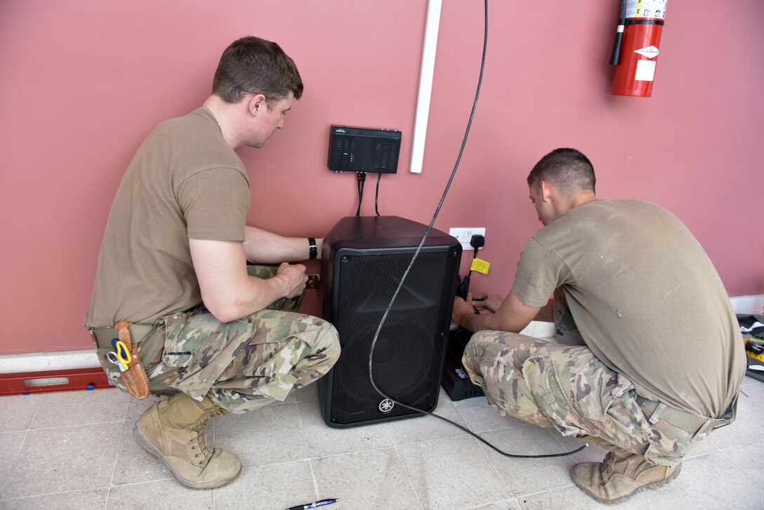 Staff Sgt. Jesse Labelle, 379th Expeditionary Communications Squadron plans and programs supervisor, and Staff Sgt. Rubin Chavez, 379 ECS cable and antenna systems supervisor, install a mass announcement system at Al Udeid Air Base, Qatar on Feb. 19, 2020. The mass announcement system will be installed in buildings across the installation, enabling more effective communication during emergencies, increasing safety and readiness for personnel at AUAB. (U.S. Air Force photo by Tech. Sgt. John Wilkes)
