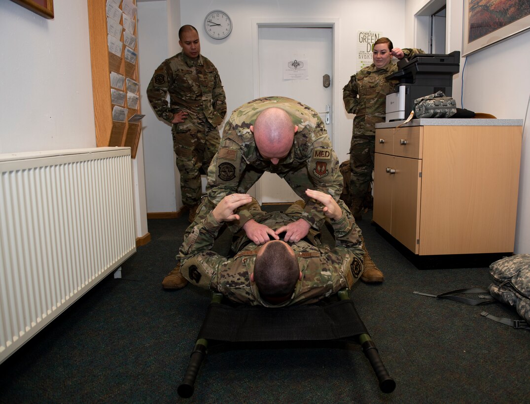 U.S. Air Force Staff Sgt. Jessop Bawek, 701st Munitions Support Squadron independent duty medical technician, straps U.S. Air Force Master Sgt. Kevin Feeney, 701st MUNNS first sergeant, to a litter at Kleine Brogel Air Base, Belgium, January 24, 2020. A litter is a medical device used to carry wounded personnel during combat or in medical emergencies. (U.S. Air Force photo by Airman 1st Class Alison Stewart)