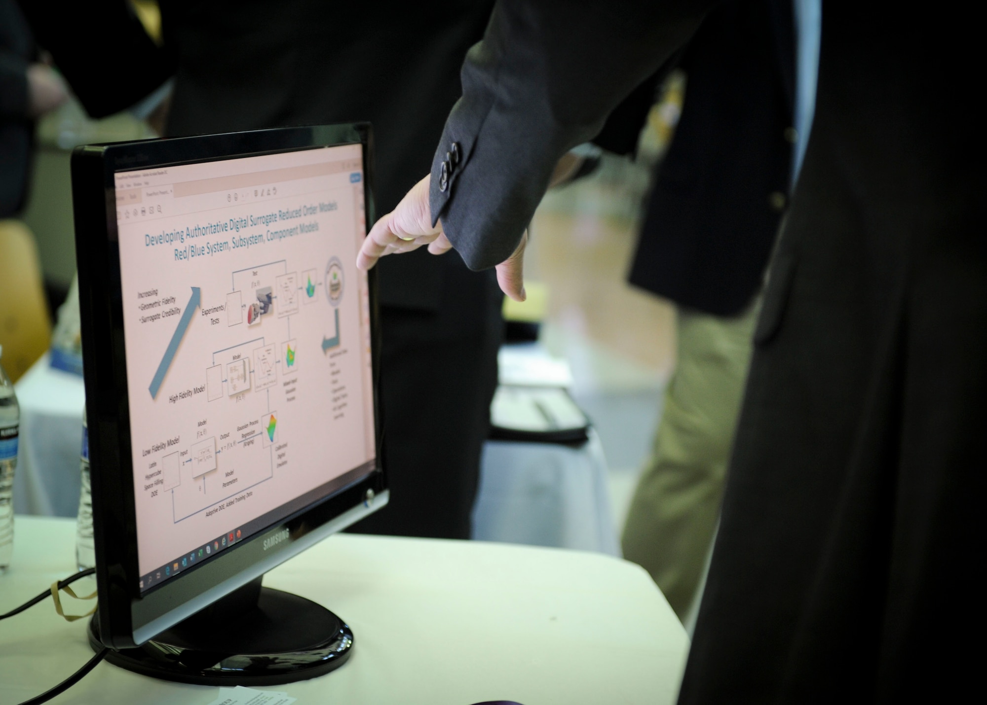 A member of the National Air and Space Intelligence Center views a scientific and engineering data analytics management and syndication display during the Small Business Innovation Research Fair at Wright-Patterson AFB, Ohio, Feb. 6, 2020. The event was structured in science fair style allowing companies to hold demonstrations and discuss their technology as applicable to NASIC missions.  (U.S. Air Force photo by Staff Sgt. Seth Ray Stang.)