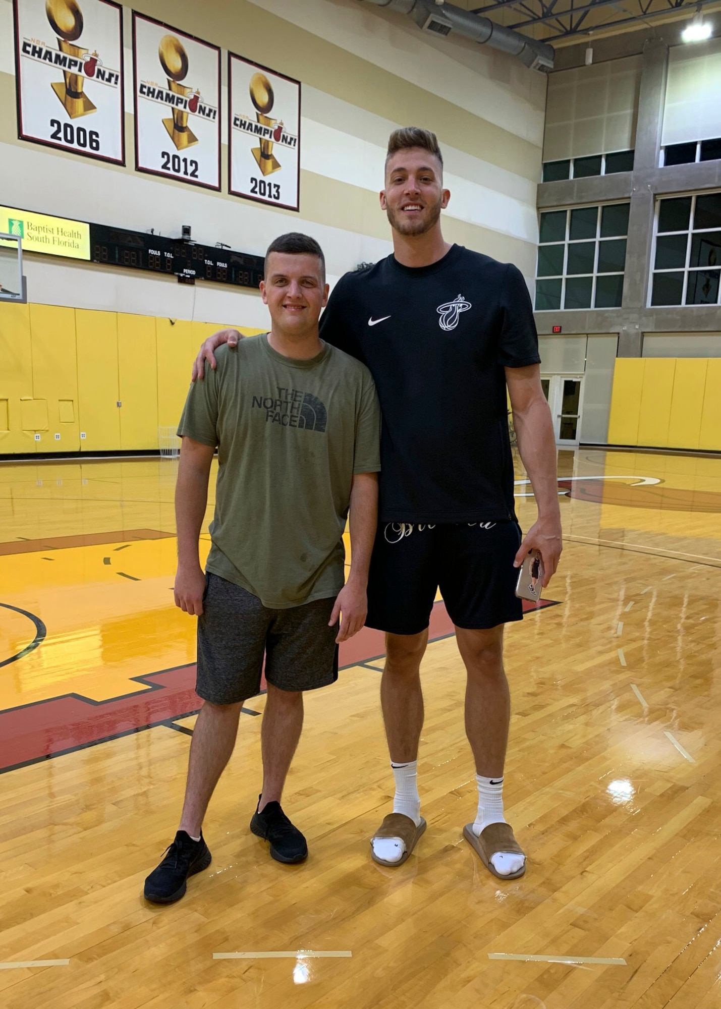 Senior Airman John Senn (left), 103rd Maintenance Squadron aerospace ground equipment maintainer, and Meyers Leonard, Miami Heat power forward, at the Miami Heat practice facility in Miami, Fla. After the two met through online gaming, Leonard helped Senn achieve his fitness goals by designing a workout and nutrition plan and checking in for weekly weigh-ins. (Courtesy photo)