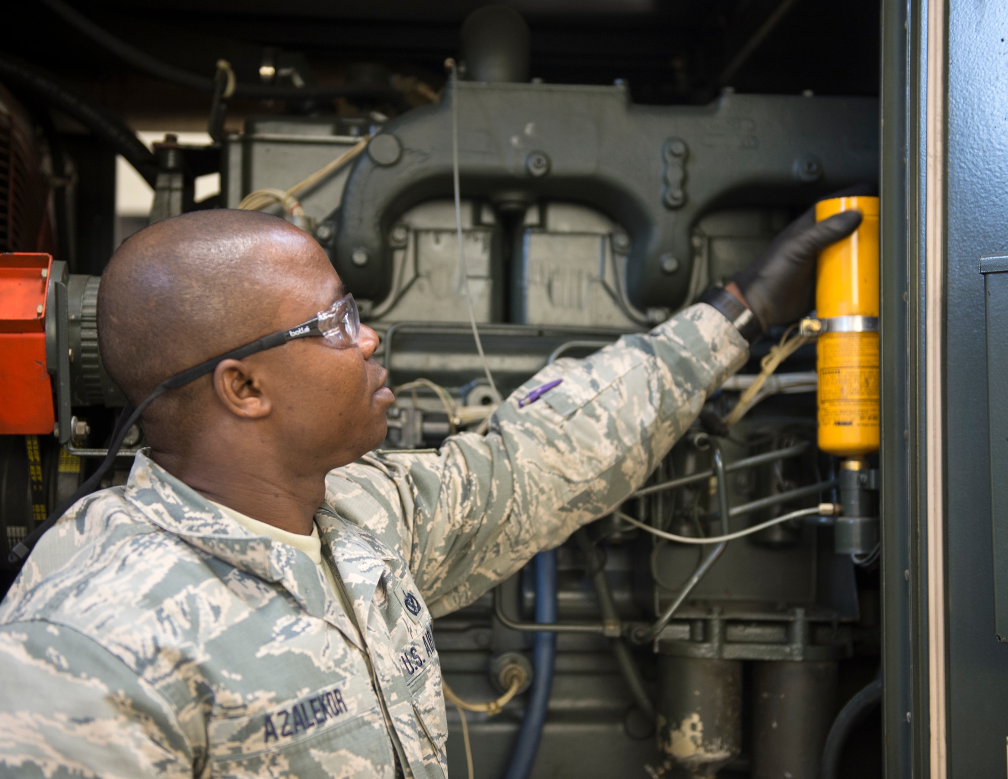 U.S. Air Force Tech. Sgt. Kokou Azalekor, an electrical power production technician with the 133rd Civil Engineer Squadron, replaces the engine start fluid cylinder in St. Paul, Minn., Feb. 12, 2020.