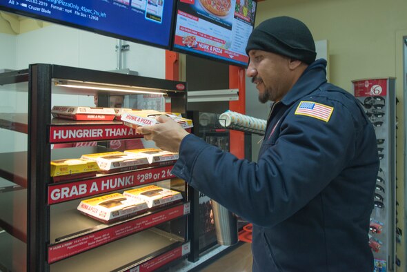A 47th Maintenance Directorate maintainer grabs a slice of pizza Feb. 12, 2020. Hunt’s Brothers Pizza, now open at the Army and Air Force Exchange Service’s shopette since last Thursday, offers pizza by either the slice or the box.
