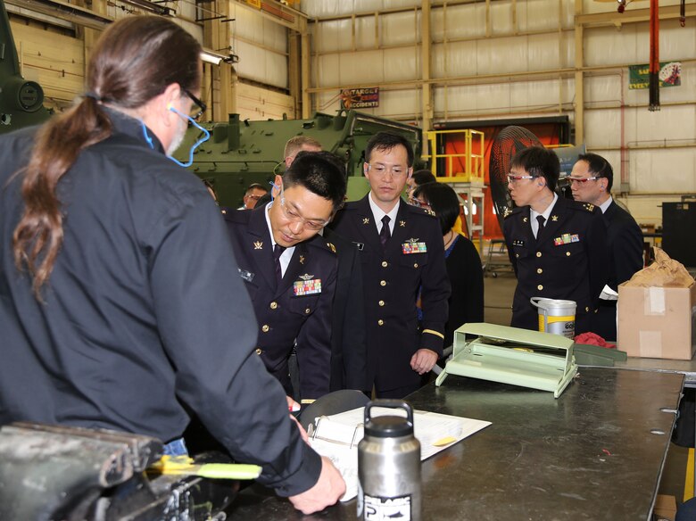 Members of the JGSDF attending the Advanced Amphibious Assault, Program Management Review discuss maintenance processes with civilian-Marines during a tour of Marine Depot Maintenance Command’s Production Plant Albany, Georgia, Feb. 18.