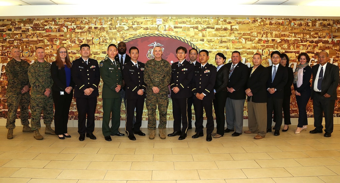 Japanese Ground Self-Defense Force Colonels Chikao Kuramochi, center right, arms section chief, Logistics Department, Ground Staff Office, and Masayuki Endo, center left, project manager, Acquisition, Technology, and Logistics Agency, pose with Col. Aaron A. Angel, director, Weapons Systems Management Center, Marine Corps Logistics Japanese Ground Self-Defense Force Colonels Chikao Kuramochi, center right, arms section chief, Logistics Department, Ground Staff Office, and Masayuki Endo, center left, project manager, Acquisition, Technology, and Logistics Agency, pose with Col. Aaron A. Angel, director, Weapons Systems Management Center, Marine Corps Logistics Command, members of the JGSDF delegation, and Marines and Civilian-Marines of Marine Corps Systems Command while at MARCORLOGCOM, Albany, Georgia, Feb. 18.