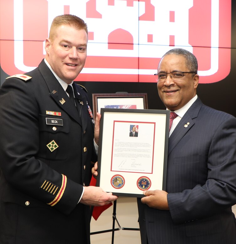 Transatlantic Division Commander Col. Christopher Beck presents Donn Booker with a letter commemorating his induction into the TAD Gallery of Distinguished Civilians. In addition to unveiling their official portraits, which will be hung in the TAD Headquarters Executive Conference Room in Winchester, Va., both inductees were also presented personalized, framed letters that include copies of their official portraits and the TAD commander’s coin.