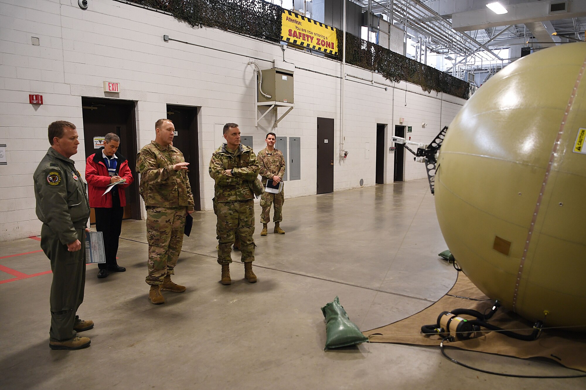 Photo of Airmen looking at a communications package antenna