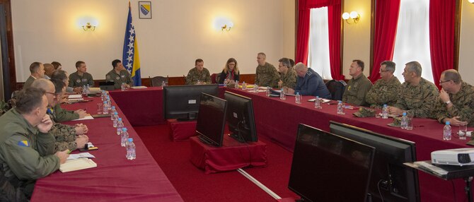 Service members sit around a conference table.