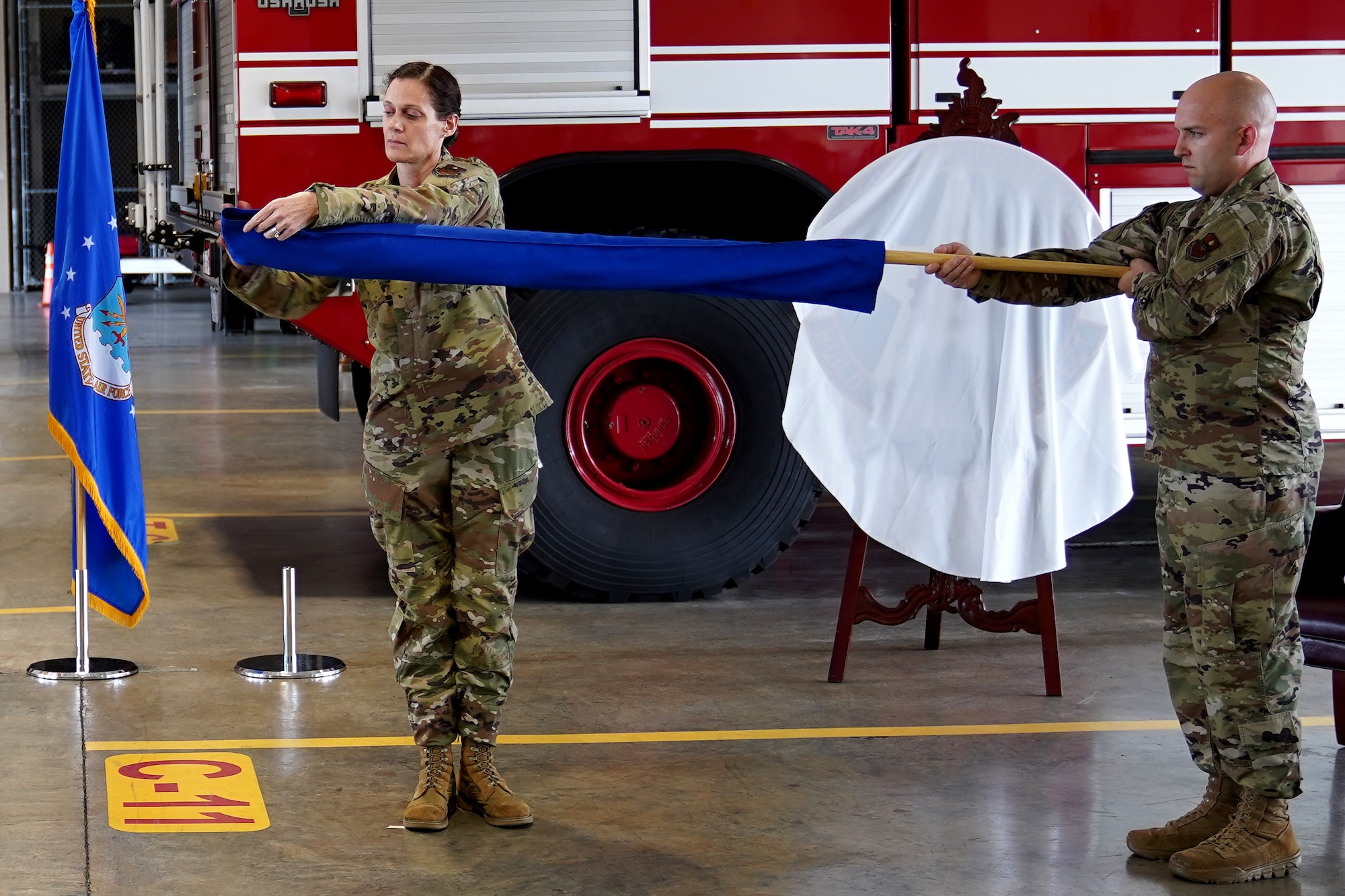 U.S. Air Force Col. Marcia Quigley, 81st Mission Support Group commander, and Senior Master Sgt. Jeremy Davis, 81st Civil Engineering Squadron first sergeant, unsheathe the 81st CES guidon during the 81st CES reactivation ceremony inside the Keesler Fire Department at Keesler Air Force Base, Mississippi, Feb. 18, 2020. The 81st CES reactivation links contractors and military members from base operations support and the 81st Infrastructure Division with a proper chain of command. (U.S Air Force photo by Airman 1st Class Kimberly Mueller)