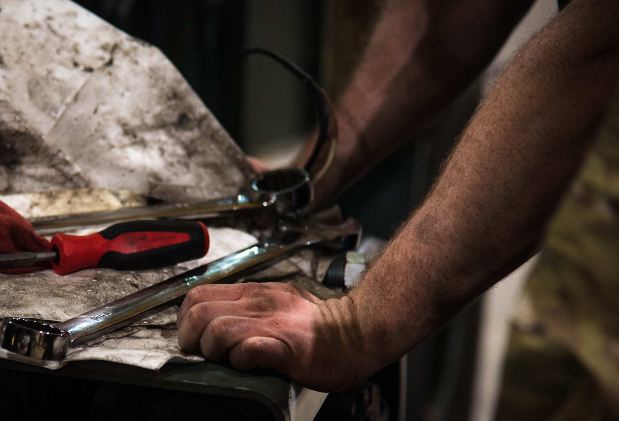 Airman 1st Class Devon Jenney places his hands next to his tools.
