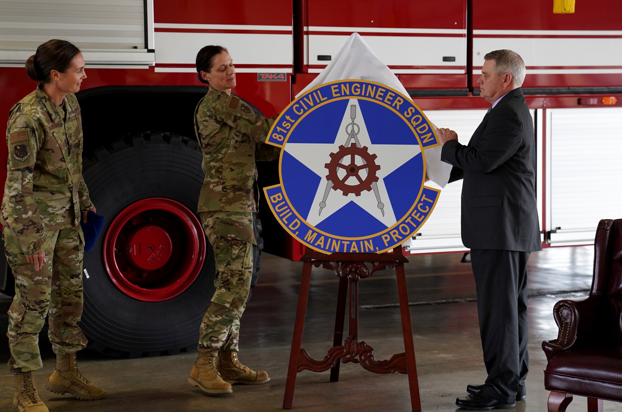 U.S. Air Force Col. Heather Blackwell, 81st Training Wing commander, Col. Marcia Quigley, 81st Mission Support Group commander, and Robert Moseley, 81st Civil Engineering Squadron director, unveil the 81st CES logo during the 81st CES reactivation ceremony inside the Keesler Fire Department at Keesler Air Force Base, Mississippi, Feb. 18, 2020. The 81st CES reactivation links contractors and military members from base operations support and the 81st Infrastructure Division with a proper chain of command. (U.S Air Force photo by Airman 1st Class Kimberly Mueller)