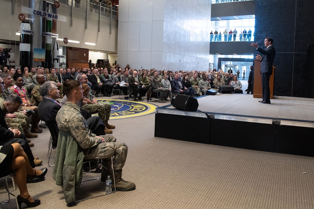 Defense Secretary Dr. Mark T. Esper stands on a stage and speaks to an audience.