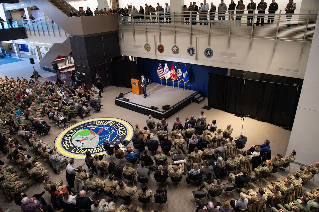 Defense Secretary Dr. Mark T. Esper stands on a stage speaking to an audience as seen from above.