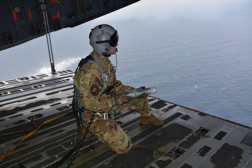 A test participant from Alaska Air National Guard unit prepares to deploy a MK25 maritime position marker from the ramp of a C-17A aircraft during AMC Test and Evaluation’s tactics, development and evaluation test on Jan. 22, 2020.  Testing executed over open waters about 40 miles off the Atlantic coast of Florida.  This operational test will evaluate the protocols for deployment of flares and position markers from a C-17 aircraft to provide expanded capabilities for NASA crewed space flight rescues.