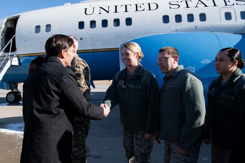 Defense Secretary Dr. Mark T. Esper shakes hands with airmen.