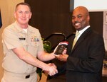 KING GEORGE, Va. (Feb. 18, 2020) – Capt. Casey Plew, Naval Surface Warfare Center Dahlgren Division (NSWCDD) commanding officer, presents a plaque to Jimmy Smith – Department of the Navy Office of Small Business Programs director – in appreciation of Smith’s keynote speech at the 2020 African American and Black History Month Observance. “Lock in your morals,” Smith advised the audience of military, government and contractors, attending the observance, while recounting his civilian career at the Naval Sea Systems Command. “If you compromise yourself anywhere along the way, that means you will compromise yourself again later. Lock yourself into your morals.”  (Photo by U.S. Navy/Released)