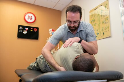 Jason Wheeler, 559th Medical Squadron Diagnostics and Therapeutics Flight physical therapy, administers treatment to his flight chief, Master Sgt. Jeremiah Taylor, in the Joint Base San Antonio-Randolph Physical Therapy Clinic. Wheeler was recognized this month as the Air Force Medical Service Biomedical Clinician Civilian of the Year for 2019.