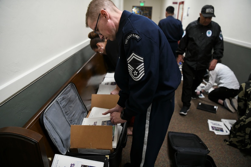 Senior Master Sgt. Ryan Dolan, U.S. Air Force Band Singing Sergeants bass vocalist, prepares programs to be distributed before a show in Fullerton, Ca., Feb. 11, 2020. The singers have a lot of preparation for shows outside of just rehearsing including preparing programs, selecting venues, managing travel plans and social media. (U.S. Air Force photo by Airman 1st Class Spencer Slocum)