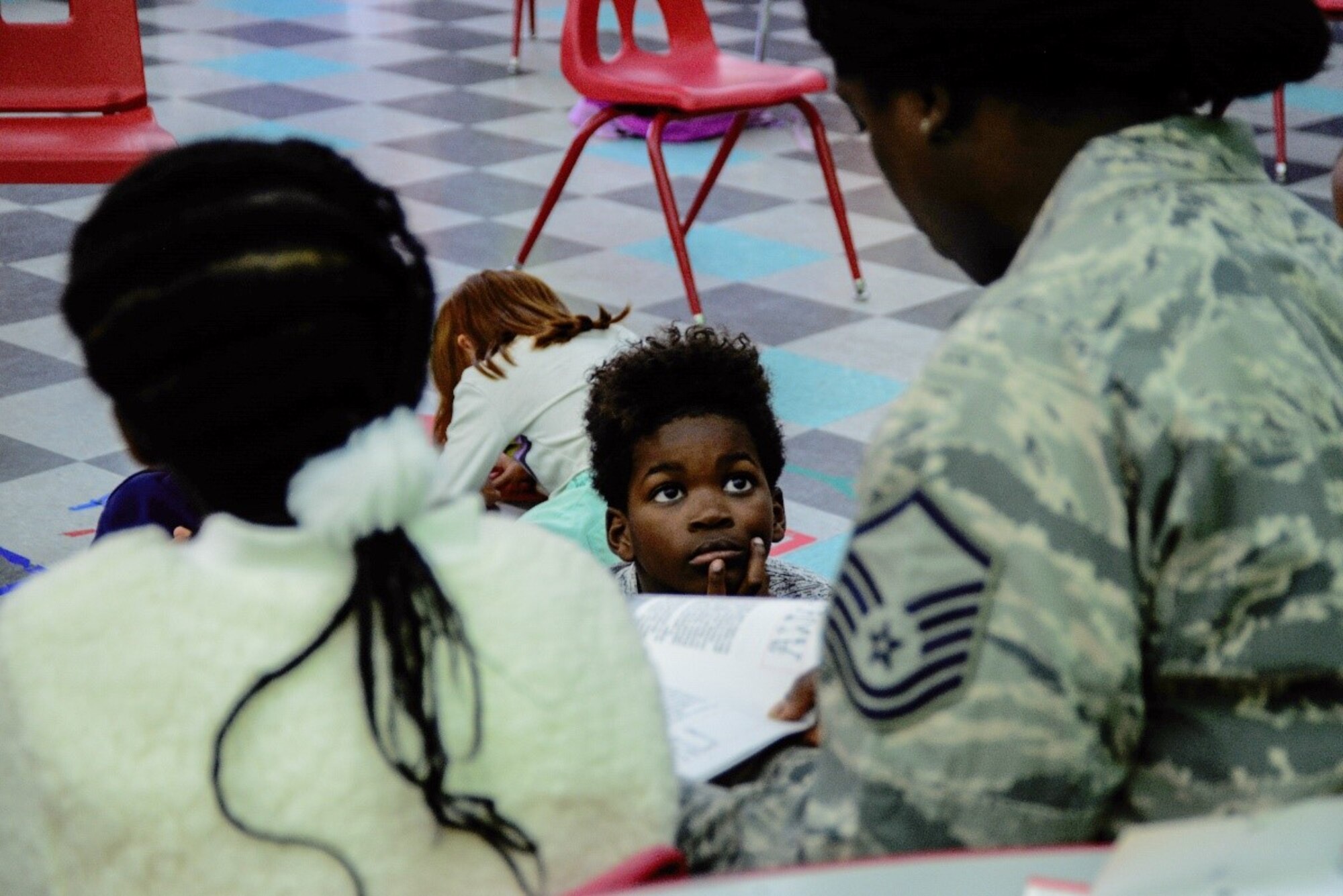 A Master Sgt. reads to a child at the Kirtland Youth Center.