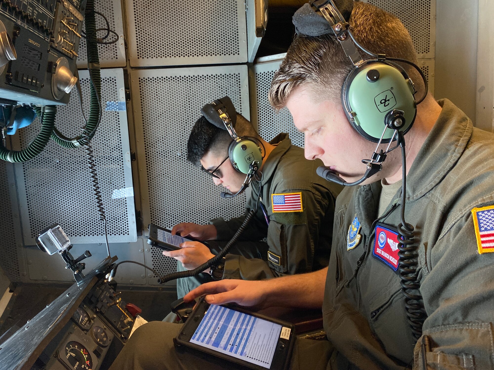 Two boom operators look over checklists on their tablets