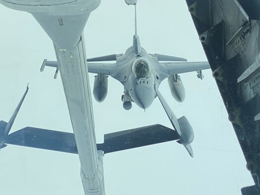 An F-16 Fighting Falcon aircraft flying toward a KC-10 aerial refueling boom