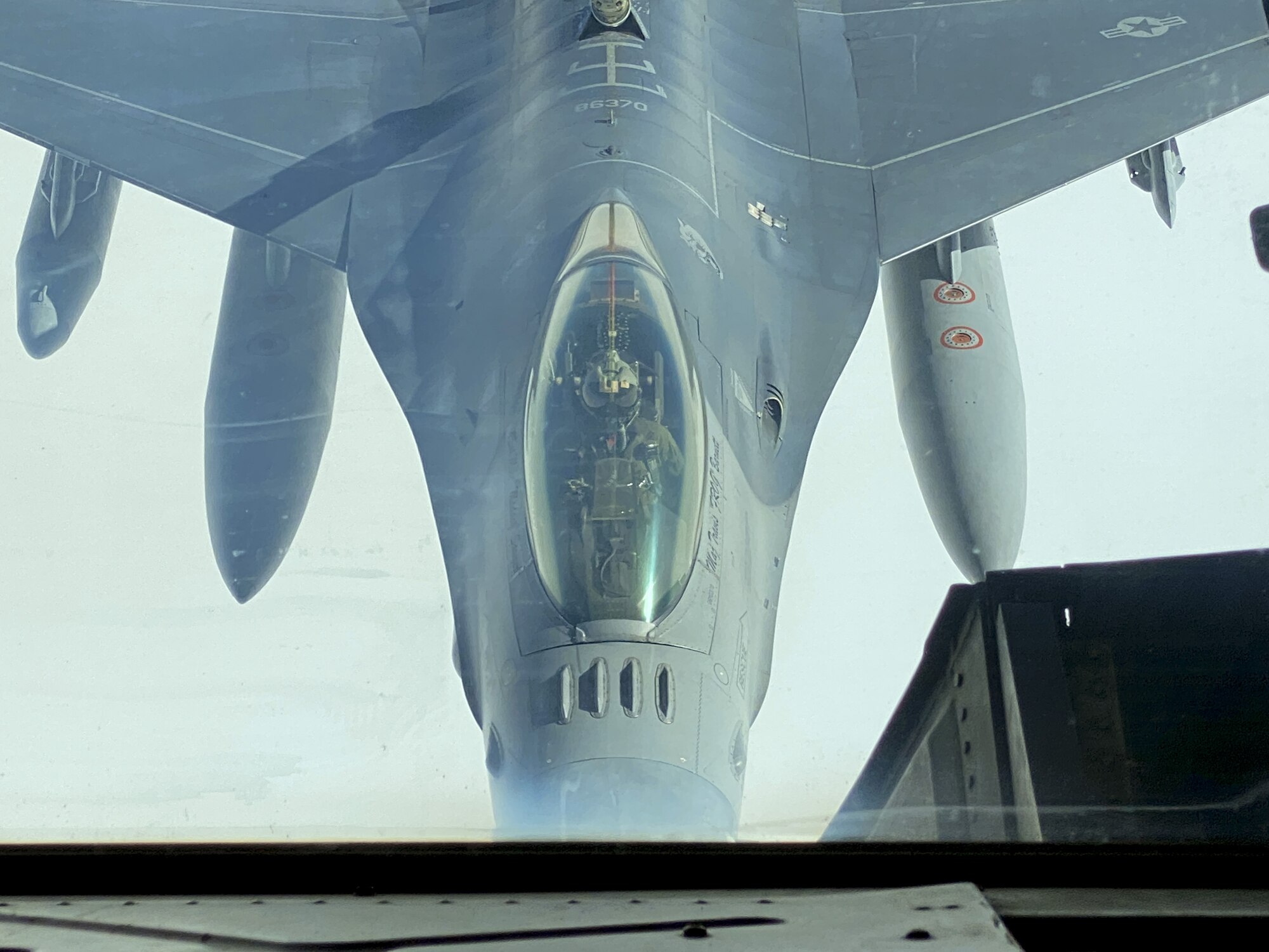 An F-16 Fighting Falcon in flight under a KC-10 Extender