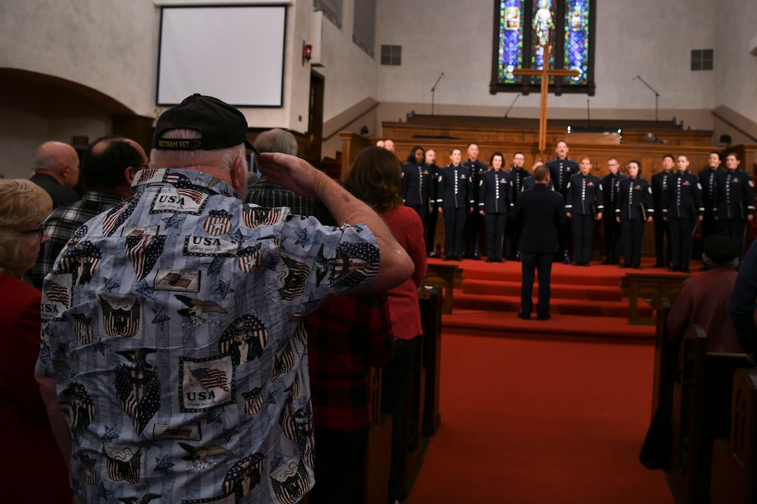 A U.S. Air Force veteran salutes during the signing of the national anthem at the beginning of a U.S. Air Force Band Singing Sergeants concert in Fullerton, Ca., Feb. 11, 2020. The singers perform the national anthem at the beginning of every concert. (U.S. Air Force photo by Airman 1st Class Spencer Slocum)