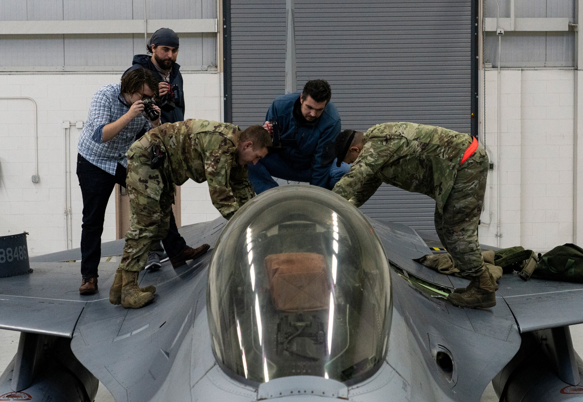 people standing by an F-16 airplance