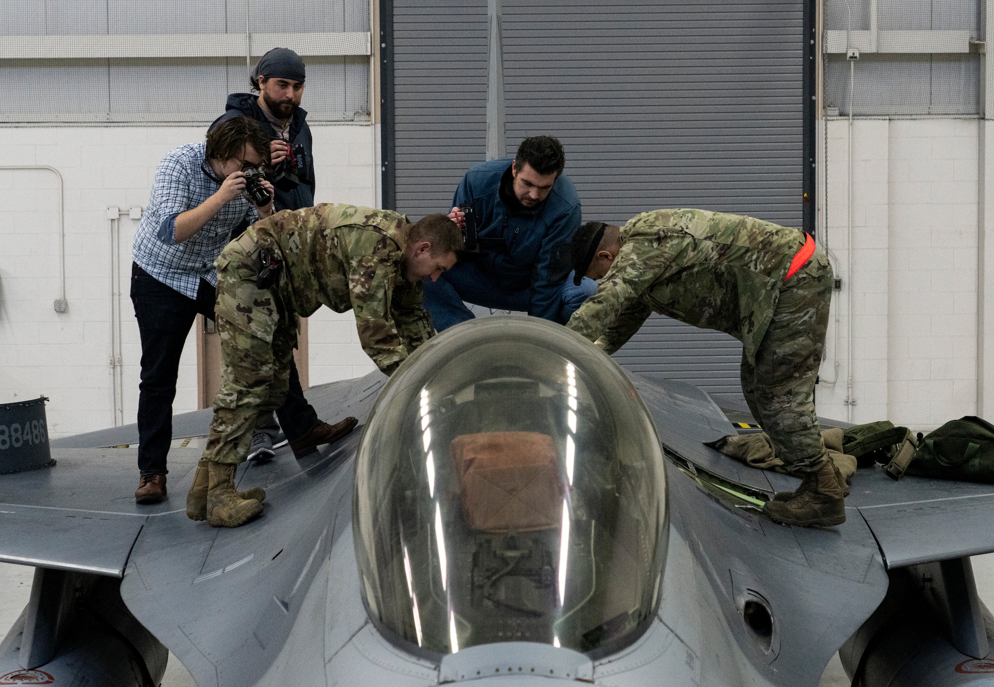 people standing by an F-16 airplance