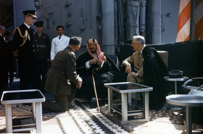 200221-N-NO101-155
WASHINGTON (Feb. 21, 2020) In this file photo taken Feb. 14, 1945, President Franklin Delano Roosevelt, right, and King Abdul Aziz Ibn Saud of Saudi Arabia confer aboard USS Quincy (CA 71). The monarch speaks to Col. Willaim A. Eddy, who interprets the conversation, and Fleet Adm. William D. Leahy is at left. (U.S. Army Signal Corps photo/Released)