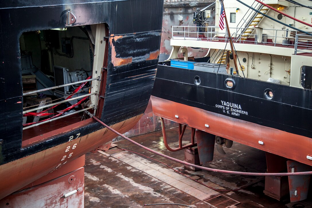 The Dredge Essayons receives an entirely new steering system that requires cutting holes on both sides of the ship. Inside the ship, two workers weld in the port-side rudder bearing assembly