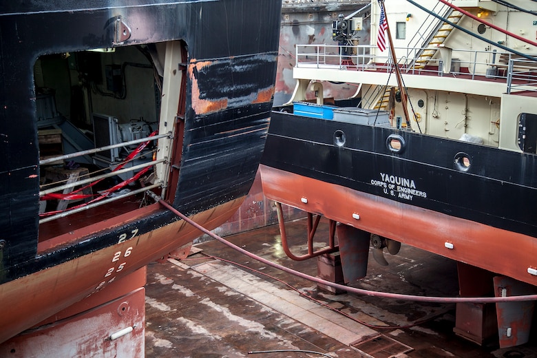 The Dredge Essayons receives an entirely new steering system that requires cutting holes on both sides of the ship. Inside the ship, two workers weld in the port-side rudder bearing assembly