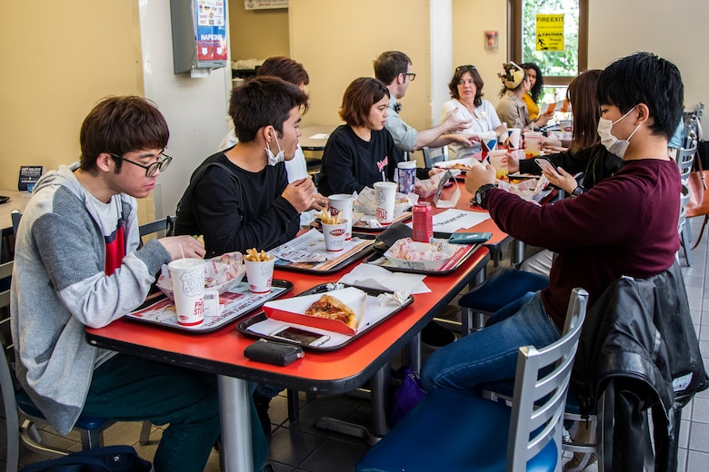 沖縄大学の学生たちが基地内のフードコートでランチを食べています。