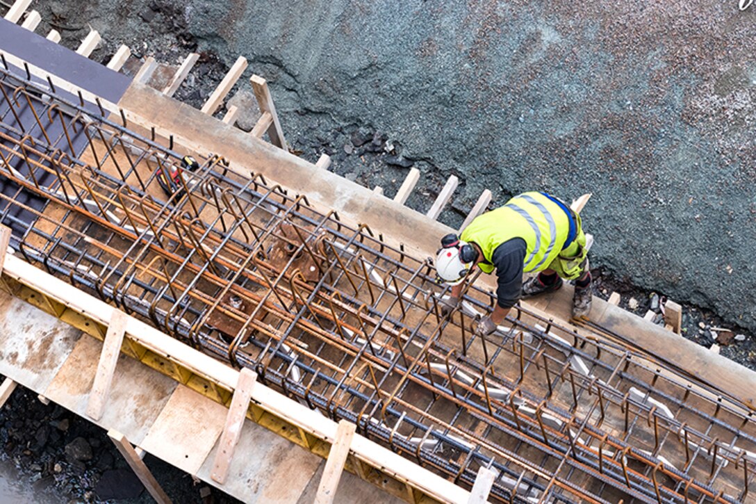 Top view of a builder worker working on a concrete construction under the bridge of Tromso, Norway