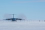 A plane lands on an icy runway.