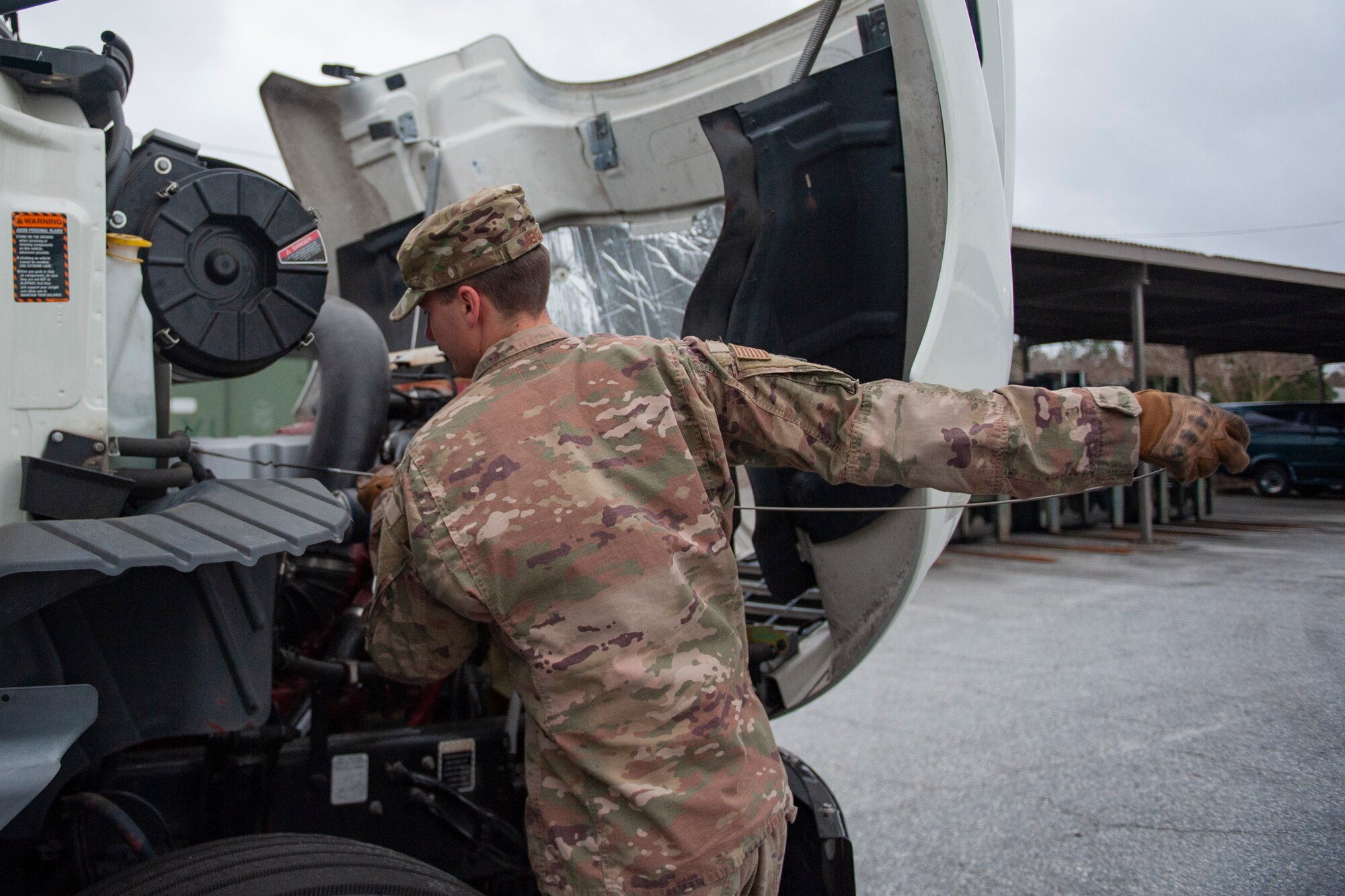 Photo of an Airman performing an inspection on a truck