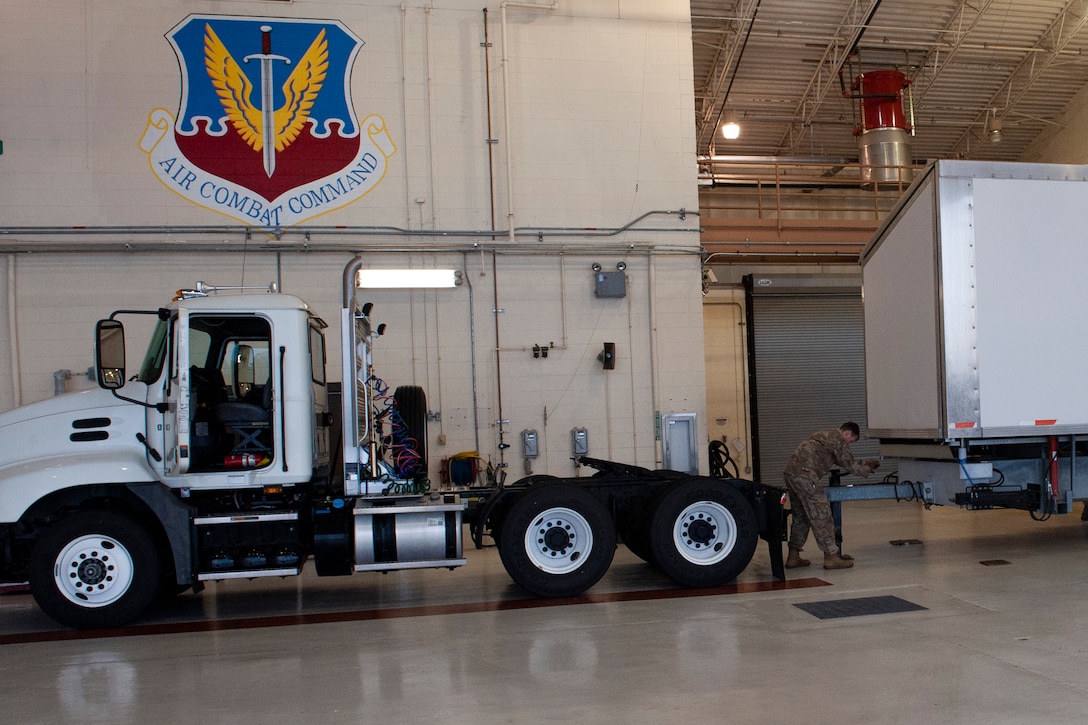 Photo of an Airman unhooking a mobile stage from a truck