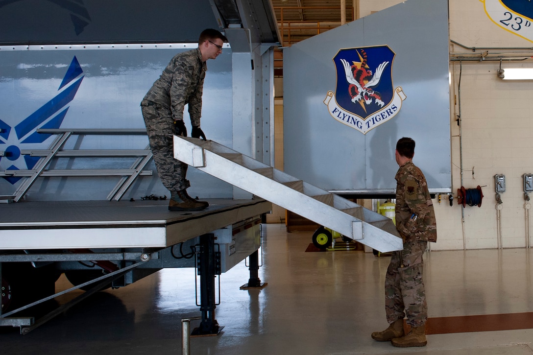 Photo of Airmen setting up a mobile stage staircase