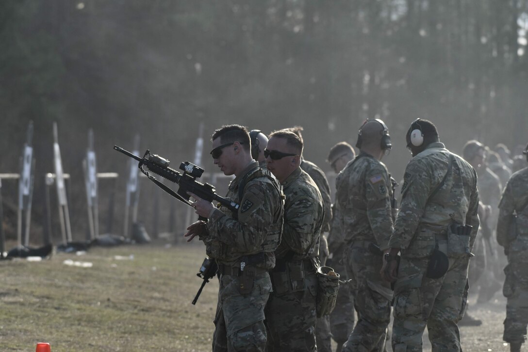 U.S. Army Soldiers take turns firing the M9 at targets during the Urban Rifle Marksmanship portion of the Master Marksmen Trainer Course at Joint Base Langley-Eustis, Virginia, Jan. 27, 2020.