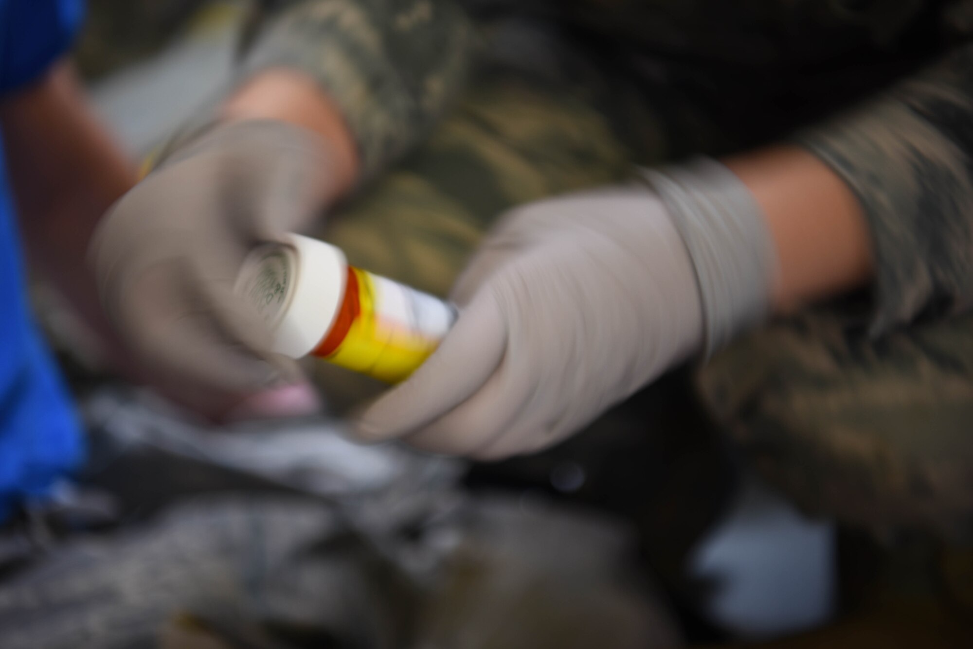An Airman from the 14th Medical Group hastily opens a pill bottle during the Tactical Combat Casualty Care Course in the Walker Center Feb. 23, 2020, on Columbus Air Force Base Miss. Classroom training is a significant part of the course, but the final hurdle is stress-testing students under simulated battlefield conditions, complete with wounded and sounds of weapons fire, sirens and screaming. (U.S. Air Force photo by Airman 1st Class Jake Jacobsen)