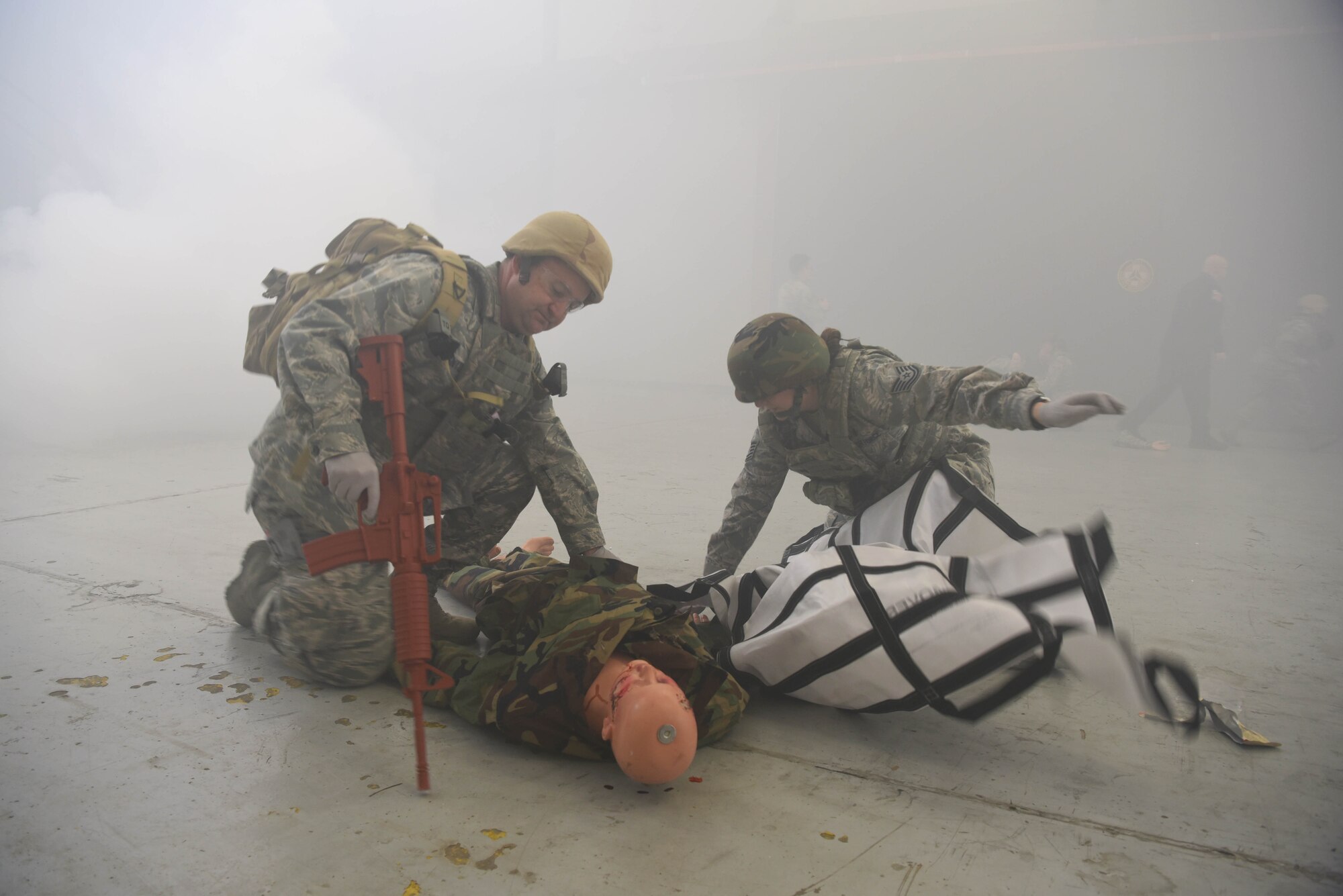 Airmen from the 14th Medical Group unwrap a tarp to carry the dummy off with during the Tactical Combat Casualty Care Course in the Walker Center Feb. 23, 2020, on Columbus Air Force Base Miss. The event challenged medics to perform battlefield care in a simulated combat environment to help bolster their medical skills by performing on actors and dummies. (U.S. Air Force photo by Airman 1st Class Jake Jacobsen)
