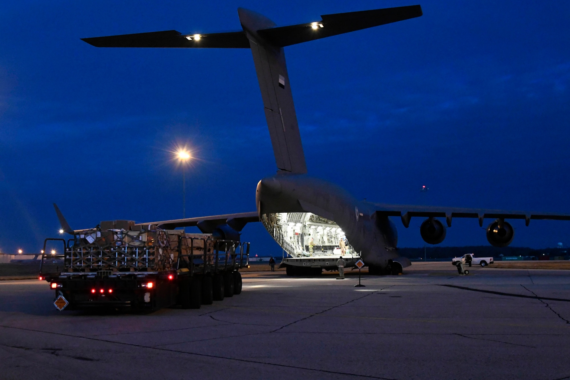 A K-loader moves into position behind a United Arab Emirates (UAE) air force C-17 Globemaster III Jan. 26, 2020, at Dover Air Force Base, Del. The K-loader was transporting cargo sold to the UAE through the foreign military sales program. (U.S. Air Force photo by Senior Airman Eric M. Fisher)