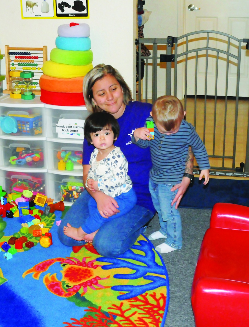 A woman provides child care to two children.