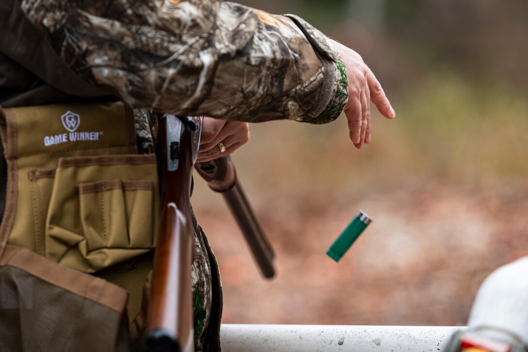 A photo of an Airman dropping a spent shell casing