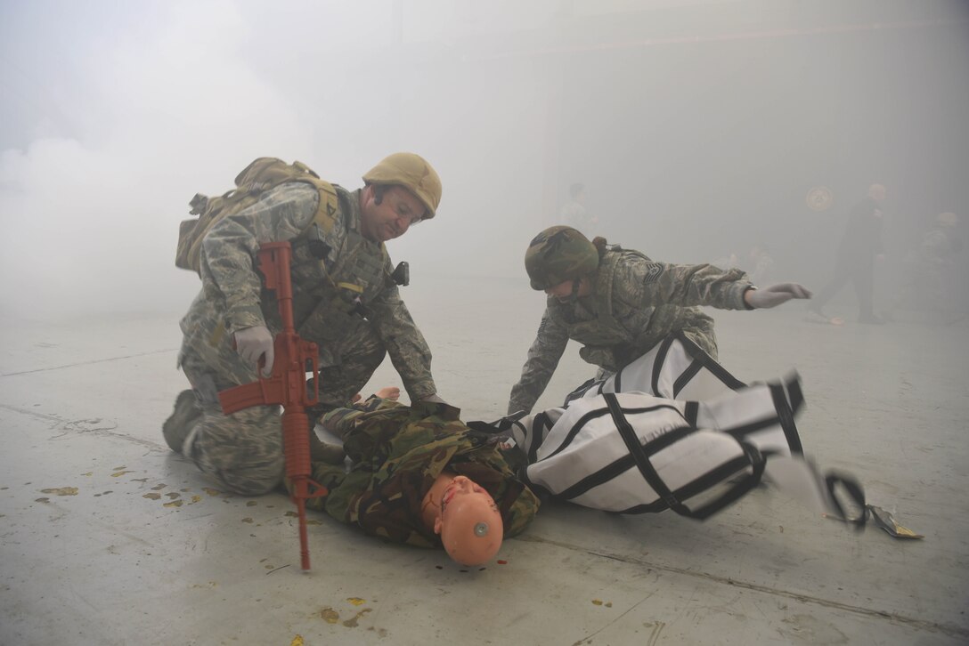 Airmen from the 14th Medical Group unwrap a tarp to carry the dummy off with during the Tactical Combat Casualty Care Course in the Walker Center Feb. 23, 2020, on Columbus Air Force Base Miss. The event challenged medics to perform battlefield care in a simulated combat environment to help bolster their medical skills by performing on actors and dummies. (U.S. Air Force photo by Airman 1st Class Jake Jacobsen)