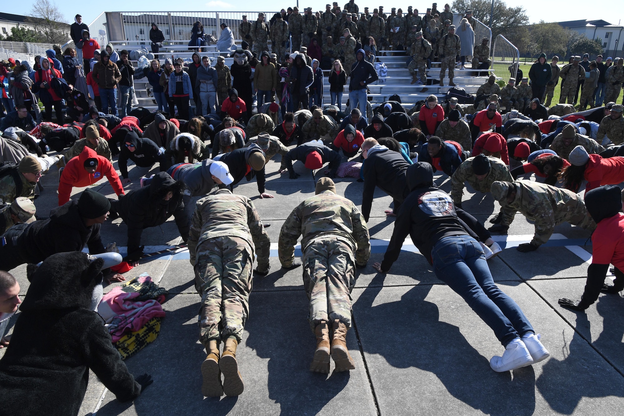 Airmen from the 335th Training Squadron do victory push-ups following the announcement that the 335th TRS placed first overall during the 81st Training Group drill down on the Levitow Training Support Facility drill pad at Keesler Air Force Base, Mississippi, Feb. 21, 2020. Airmen from the 81st TRG competed in a quarterly open ranks inspection, regulation drill routine and freestyle drill routine. Keesler trains more than 30,000 students each year. While in training, Airmen are given the opportunity to volunteer to learn and execute drill down routines. (U.S. Air Force photo by Kemberly Groue)
