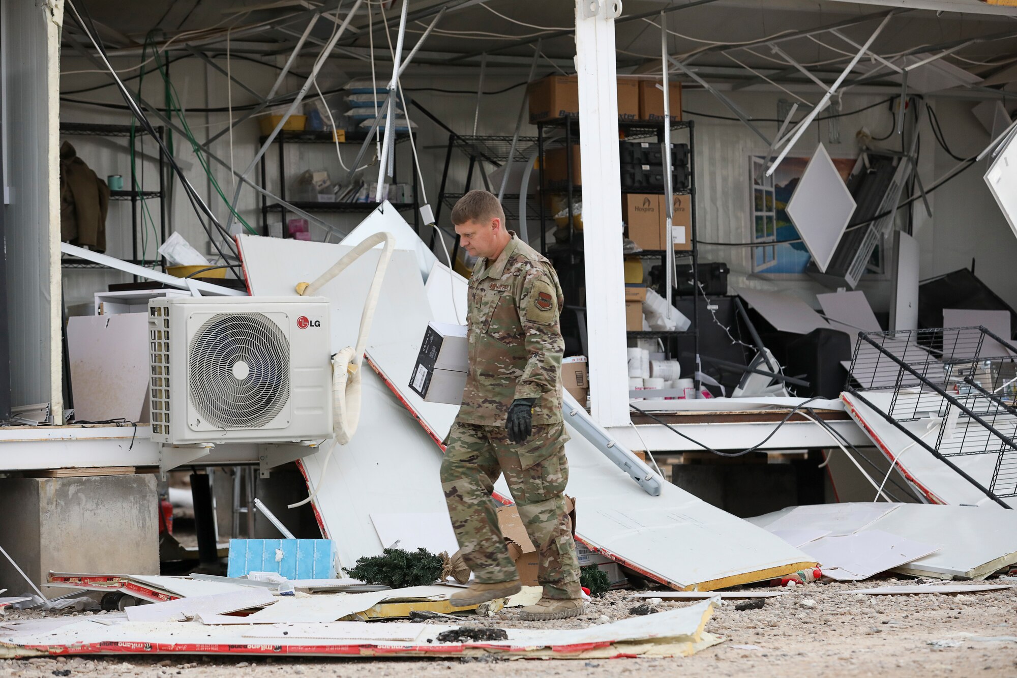 Airman walks through debris.