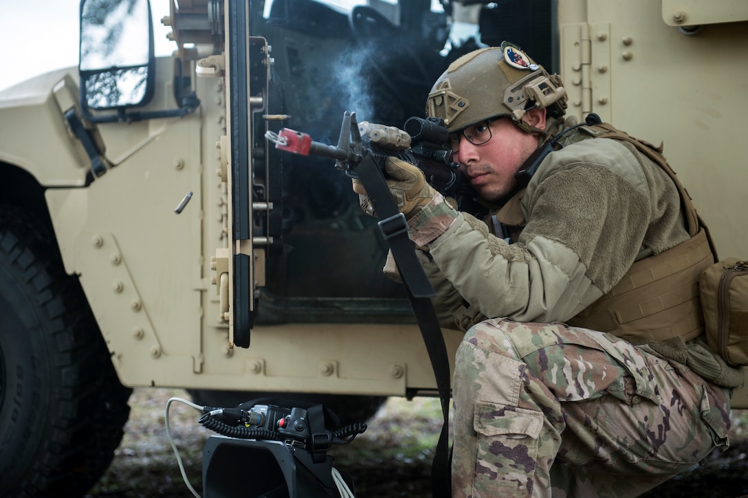 Senior Airman Jovane Concha, 321st Contingency Response Squadron security forces specialist, fires blank rounds from an M4 carbine at simulated opposing forces for a base defense training scenario during Exercise Turbo Distribution at Fort Stewart-Hunter Army Airfield, Georgia, Feb. 14, 2020. Members of the 621st Contingency Response Wing, U.S. Army 689th Rapid Port Opening Element and Defense Logistics Agency Rapid Deployment Team to become a Joint Task Force-Port Opening unit capable of deploying to provide mobility options and facilitating humanitarian and disaster relief assistance. (U.S. Air Force photo by Staff Sgt. Sarah Brice)